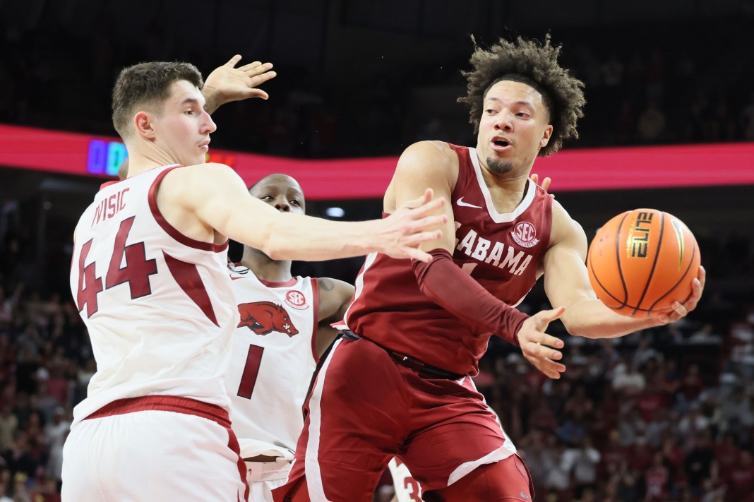 Alabama Crimson Tide guard Mark Sears (1) passes the ball in the second half as Arkansas Razorbacks forward Zvonimir Ivisic (44) defends at Bud Walton Arena on February 8, 2025. Alabama won 85-81.