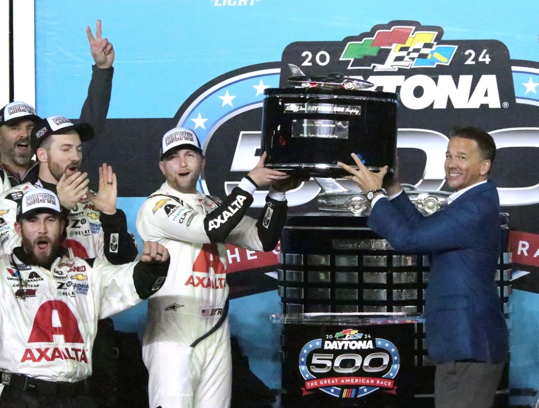 William Byron and Daytona International Speedway President Frank Kelleher lift the Daytona 500 trophy in Victory Lane on February 19, 2024, after Byron's victory in the race